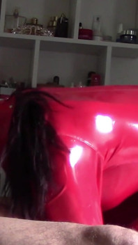 Une MILF en costume rouge en latex et talons hauts en cuir brevetés taille une pipe avec avalage