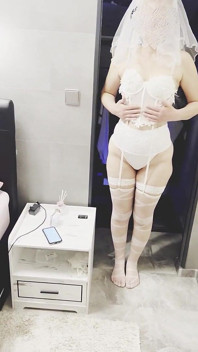 Hotwife poseert in een bruidskostuum