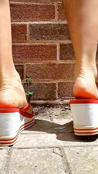 Piccoli piedi asiatici in infradito con tacco rosso