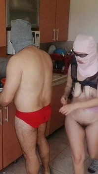 夫妇在厨房玩得很开心。性感的妻子在房子里裸体做家务