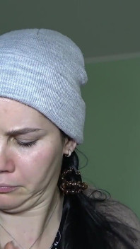 Anna está congelando e escolhendo seu nariz em um boné em casa