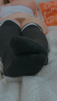 Milf met grote dijen in lange sokken masturbeert tijdens het kijken naar porno.