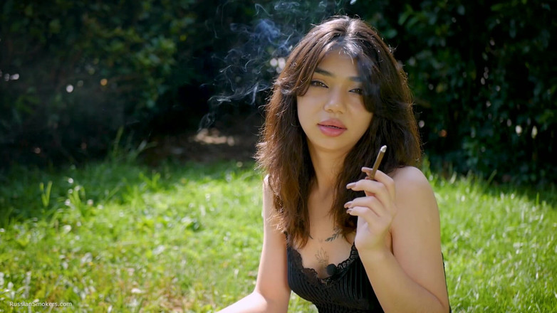 Russian Smokers: Arina Is Smoking One Black Cigarette Outdoors