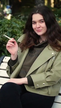 Jovem morena está dando um passeio sem pressa com cigarro Allwhite de 120mm