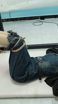 Teman wanita saya diikat pada bingkai besi, kaki telanjang tergantung dan digelitik