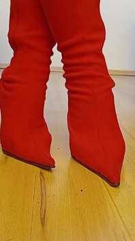 Travesti seksi kırmızı süet parmaklı yüksek topuklu çizmeler içinde yürüyor