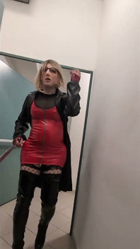 Promenade dans une maison de parking, une blonde dans des bottes overknee, robe en pvc rouge et long manteau de cuir