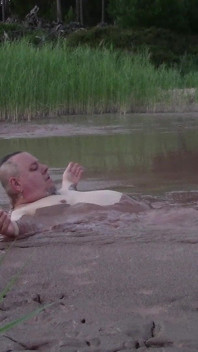 Bagno di fango in uno stagno profondo in una cava di ghiaia