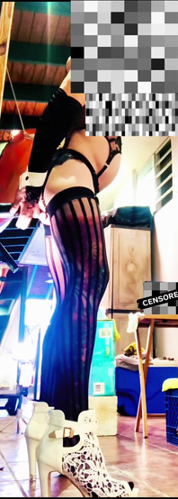 Une trans sexy vêtue de bas chevauche un gode anal au mur