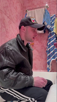 Tipul rus gopnik în jachetă de piele și pantofi sport ia un flux de urină de la un tip puternic