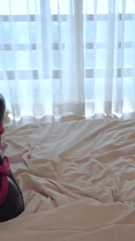 Usando un traje de látex y atado por una cuerda roja