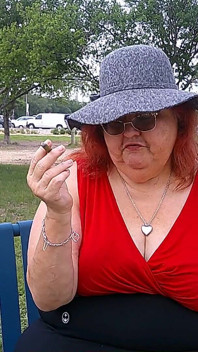 Krankenschwester Vicki raucht im park auf einer bank, ganz angezogen