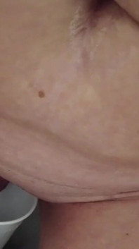O mamă sexy sportivă se pișă într-o cupă purtând un tricou sport, apoi bărbatul ei slurp pișat
