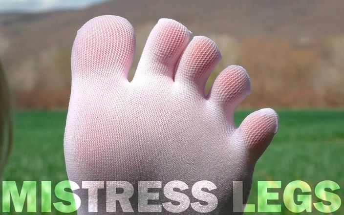 Mistress Legs: Füße in süßen weißen Socken mit jeans auf dem Grasfeld