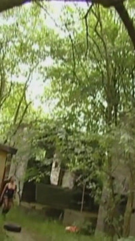 Chlap v latexových šatech ponížený na zahradě