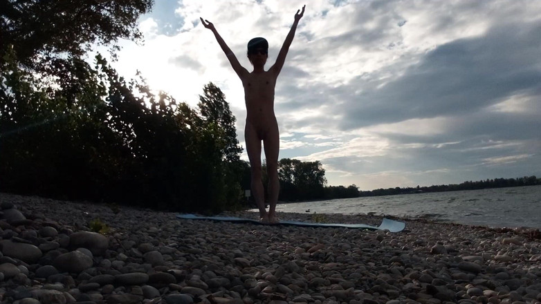 Jon Arteen: Szczupły chłopiec nudystów robi jogę nago na plaży naturystów. Nagie...
