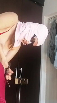 Une latina sexy s’amuse en essayant des vêtements et en les coupant