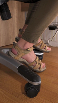 Älskar hennes fötter i slitna sandaler under bordet