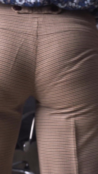 Secretară sexy tachinând linia vizibilă de chiloți în pantaloni strâmți de lucru