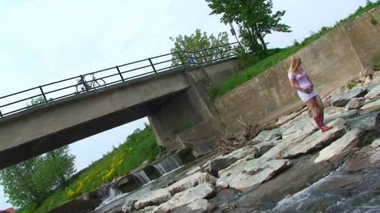 Femdom Austria: Blonde pissing outside in a river
