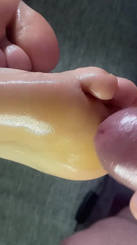 Tapak kaki berminyak yang cantik memancut mani pada kaki