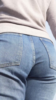 Mamă sexy cu fund gras care se plimbă în aer liber în blugi largi
