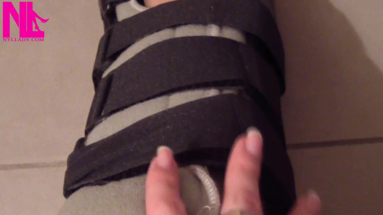 Nyllady: Nyllady sätter på legcast handledare på sina slangade fötter
