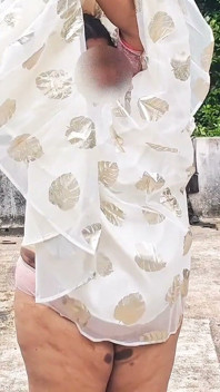 穿着白色裙子和粉红色的微胖女孩完全裸体在户外散步