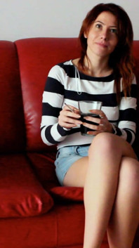Si rambut merah kurus merokok di atas sofa