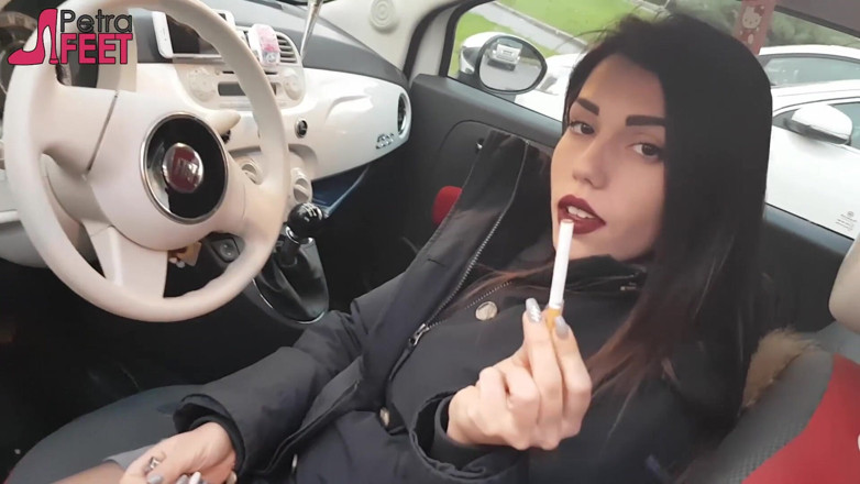 Smokin Fetish: Impresionante nena morena está fumando y jugando con los pies