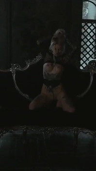 Tattooed teen is dancing in the dark room