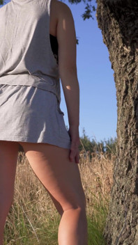 Chica en falda corta mostrando bragas de espalda completa al aire libre